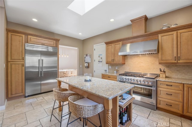 8817 Encino Ave, Sherwood Forest, CA 91325 - kitchen with premium appliances, wall chimney range hood, stone tile flooring, decorative backsplash, and recessed lighting