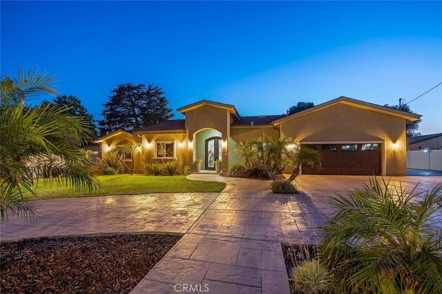 8817 Encino Ave, Sherwood Forest, CA 91325 - mediterranean / spanish-style home with stucco siding, an attached garage, driveway, and a front yard