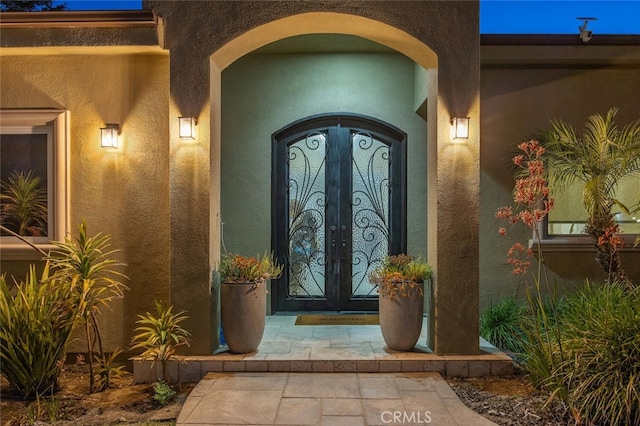 8817 Encino Ave, Sherwood Forest, CA 91325 - view of exterior entry with stucco siding and french doors