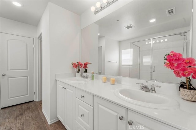 10335 Saint Andrews Ct, Adelanto, CA 92301 - bathroom featuring double vanity, wood finished floors, a stall shower, and recessed lighting