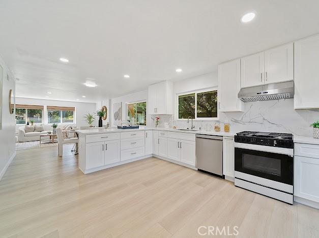 1050 Loma Verde Dr, Arcadia, CA 91006 - kitchen with dishwasher, gas range, under cabinet range hood, open floor plan, and tasteful backsplash