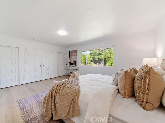 1050 Loma Verde Dr, Arcadia, CA 91006 - bedroom featuring light wood-style floors and multiple closets