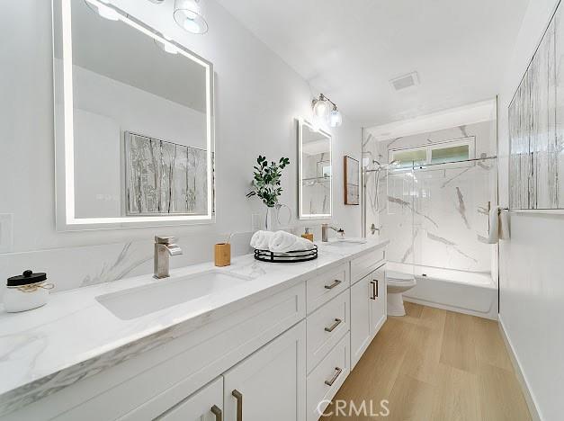 1050 Loma Verde Dr, Arcadia, CA 91006 - full bathroom with double vanity, a marble finish shower, and wood finished floors