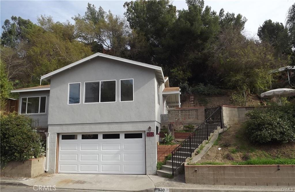 930 Mira Valle St, Monterey Park, CA 91754 - view of front of home featuring an attached garage, stairs, driveway, and stucco siding