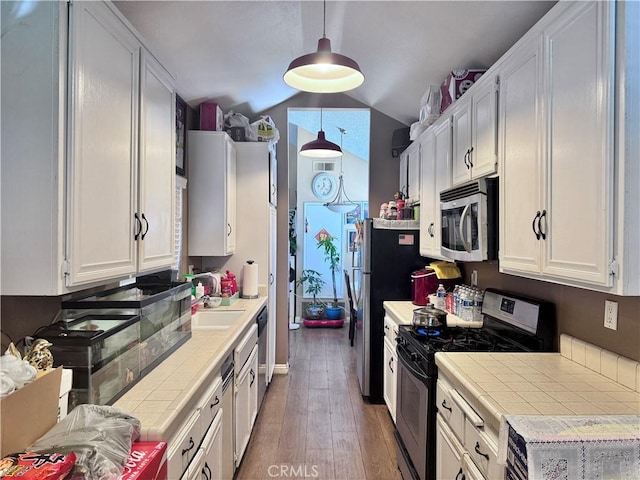 2532 W Macarthur Blvd Unit B, Santa Ana, CA 92704 - kitchen with appliances with stainless steel finishes, tile countertops, vaulted ceiling, white cabinets, and wood finished floors