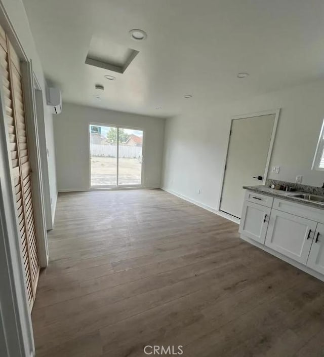 18134 Chase St, Northridge, CA 91325 - spare room featuring an AC wall unit, attic access, and wood finished floors