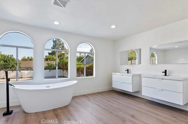 18134 Chase St, Northridge, CA 91325 - full bathroom featuring two vanities, wood finished floors, a freestanding bath, and recessed lighting