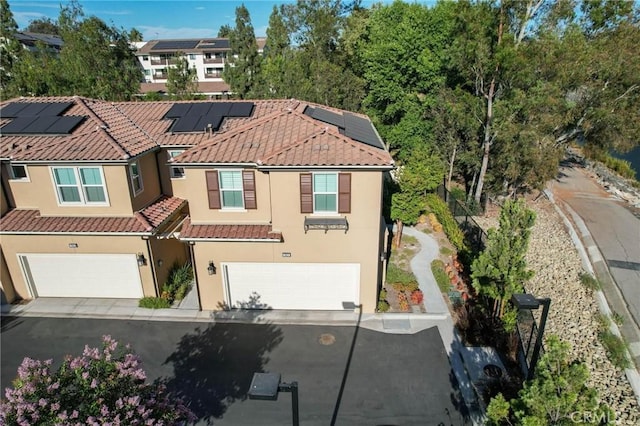 1742 Heywood St Unit C, Simi Valley, CA 93065 - multi unit property featuring a tiled roof, an attached garage, stucco siding, roof mounted solar panels, and driveway