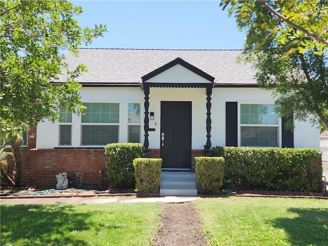 4622 Sunnyside Dr, Riverside, CA 92506 - view of front facade featuring a front lawn, a shingled roof, brick siding, and stucco siding