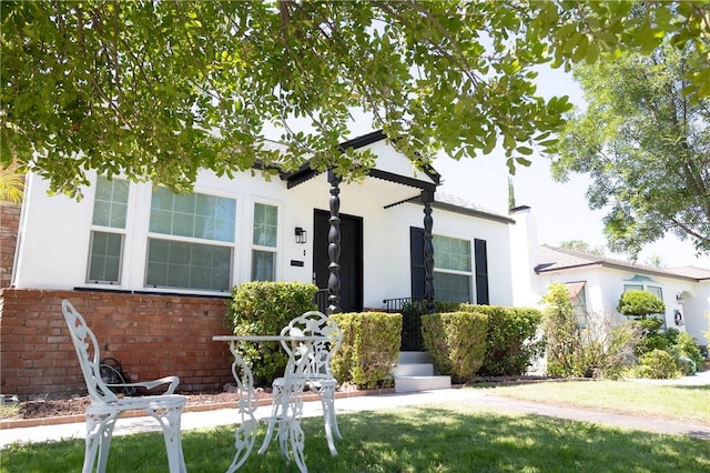 4622 Sunnyside Dr, Riverside, CA 92506 - view of front facade with brick siding, stucco siding, a front yard, and a chimney