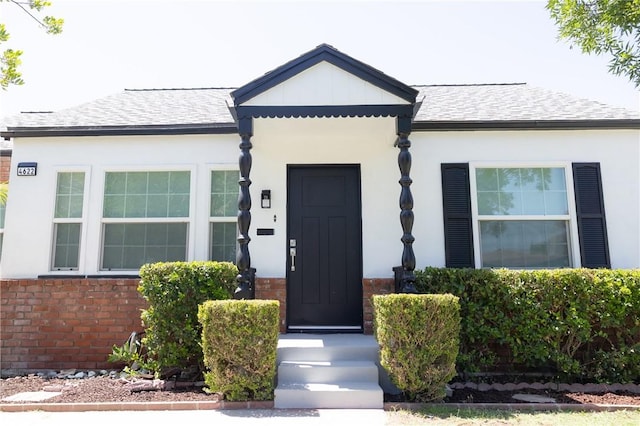 4622 Sunnyside Dr, Riverside, CA 92506 - view of front of home with stucco siding, a shingled roof, and brick siding