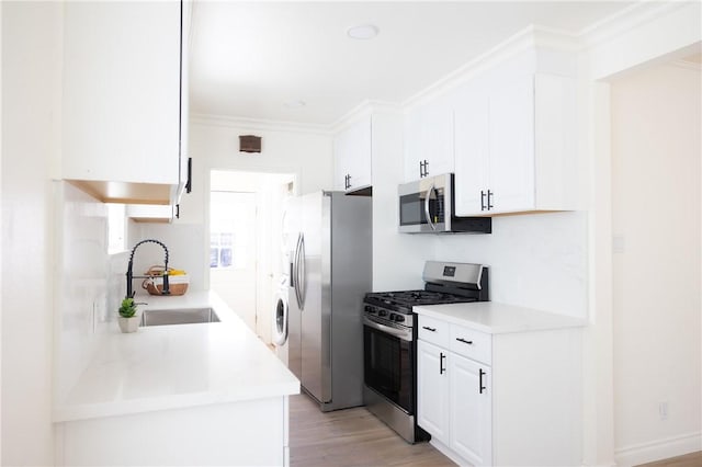 4622 Sunnyside Dr, Riverside, CA 92506 - kitchen featuring stainless steel appliances, white cabinets, crown molding, light wood-type flooring, and light countertops
