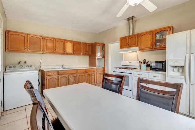 133 Lotus Dr, Chula Vista, CA 91911 - kitchen with white appliances, washer / clothes dryer, under cabinet range hood, brown cabinetry, and glass insert cabinets