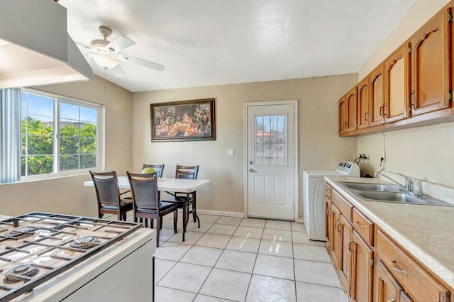 133 Lotus Dr, Chula Vista, CA 91911 - kitchen featuring ceiling fan, light countertops, light tile patterned flooring, brown cabinets, and washing machine and clothes dryer