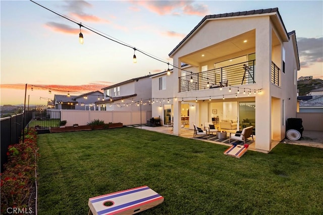 28537 Daybreak Way, Saugus, CA 91350 - back of property at dusk featuring a balcony, an outdoor hangout area, a patio area, and a fenced backyard