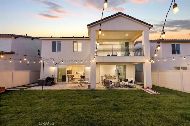 28537 Daybreak Way, Saugus, CA 91350 - back of house at dusk with a balcony, an outdoor living space, stucco siding, and a fenced backyard