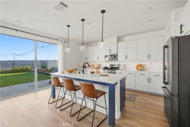 28537 Daybreak Way, Saugus, CA 91350 - kitchen with stainless steel appliances, a kitchen breakfast bar, light wood-style flooring, light countertops, and recessed lighting