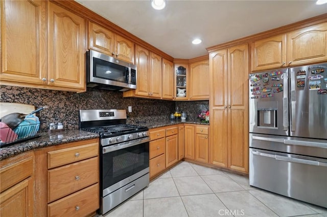 4435 Los Serranos Blvd, Chino Hills, CA 91709 - kitchen with appliances with stainless steel finishes, light tile patterned floors, dark stone counters, backsplash, and glass insert cabinets