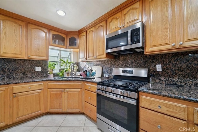 4435 Los Serranos Blvd, Chino Hills, CA 91709 - kitchen featuring stainless steel appliances, dark stone countertops, light tile patterned floors, and decorative backsplash