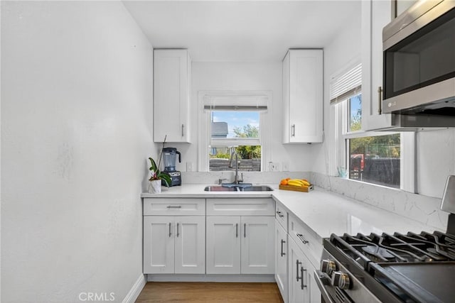 8627 John Ave, Los Angeles, CA 90002 - kitchen featuring stainless steel microwave, stove, white cabinets, and light countertops