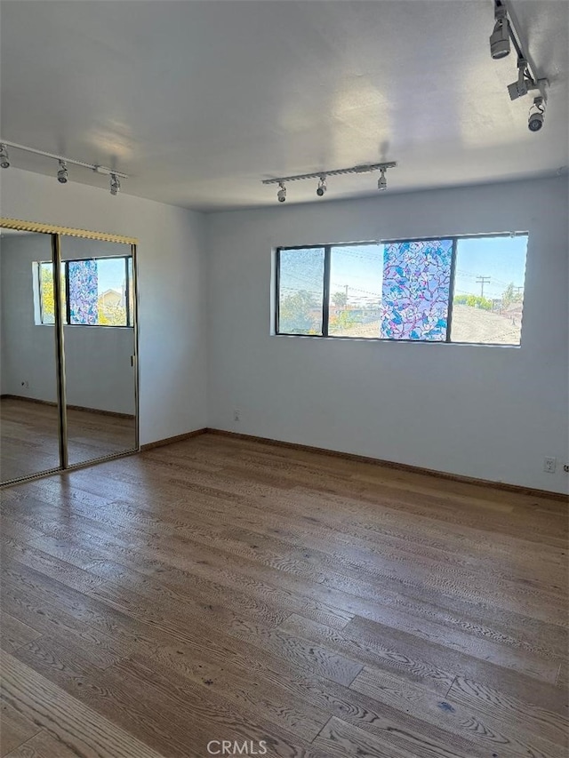 14730 S Normandie Ave Unit 3, Gardena, CA 90247 - unfurnished bedroom featuring track lighting, wood finished floors, and a closet