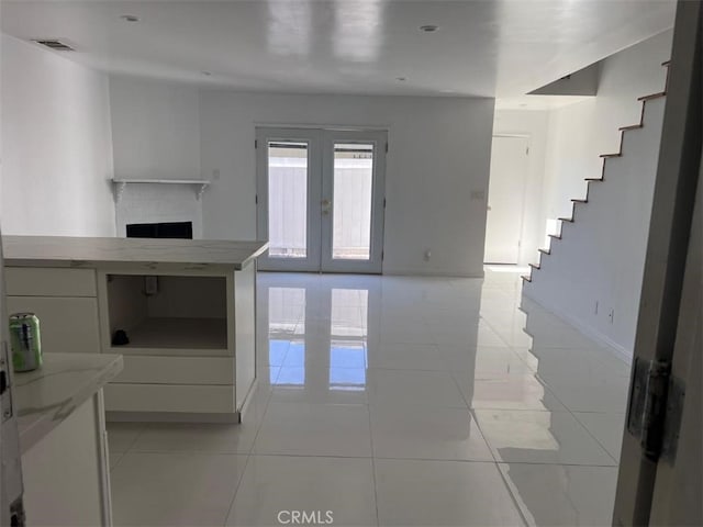 14730 S Normandie Ave Unit 3, Gardena, CA 90247 - unfurnished living room with french doors, stairway, light tile patterned floors, and a fireplace