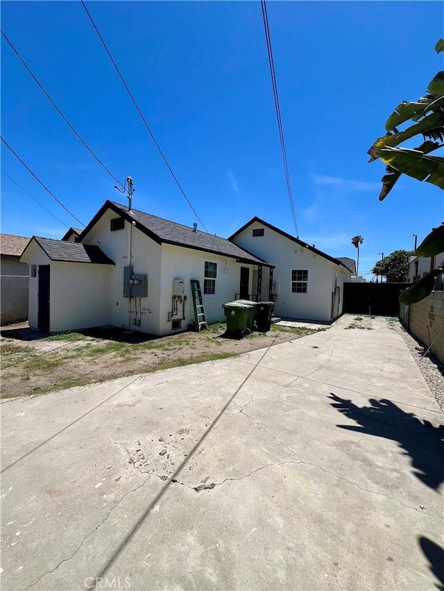 1737 W 65th Pl, Los Angeles, CA 90047 - back of house featuring stucco siding, a fenced backyard, and concrete driveway