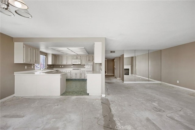 2222 S Mesa St Unit 8, San Pedro, CA 90731 - kitchen featuring open floor plan, light countertops, white appliances, a glass covered fireplace, and a peninsula
