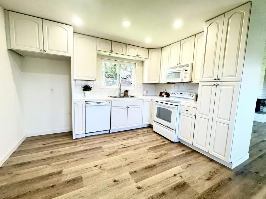 7855 Montana St, Lemon Grove, CA 91945 - kitchen featuring white appliances, tasteful backsplash, light wood-type flooring, light countertops, and recessed lighting