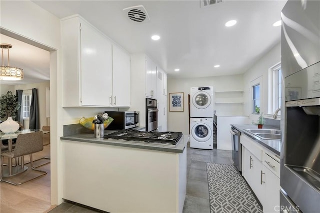 14453 Watkins Dr, La Mirada, CA 90638 - kitchen featuring estacked washer and dryer, appliances with stainless steel finishes, white cabinetry, dark countertops, and recessed lighting