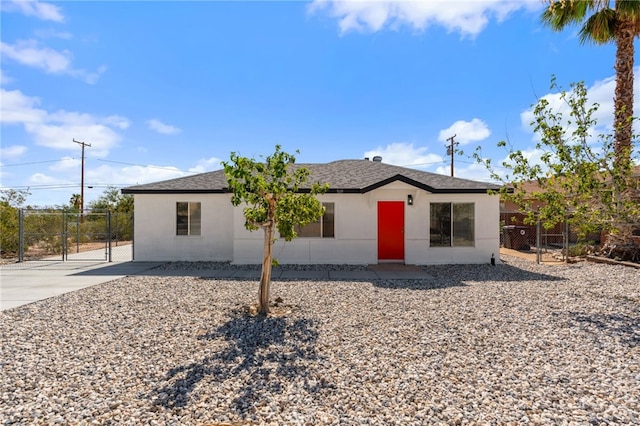 5619 Daisy Ave Unit 29, Palms, CA 92277 - view of front facade featuring a gate, stucco siding, and a shingled roof