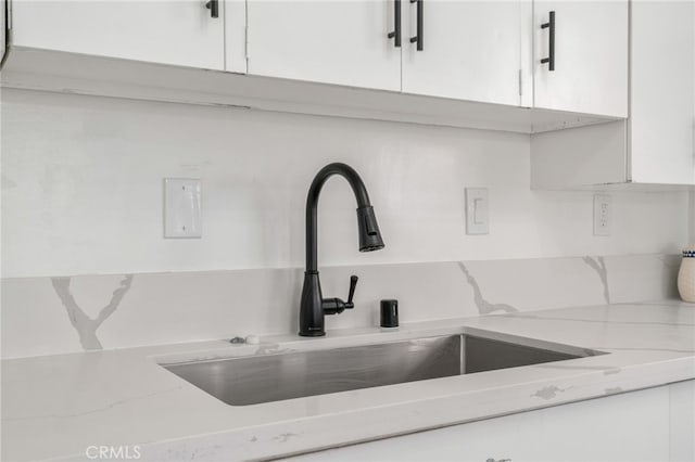 5619 Daisy Ave Unit 29, Palms, CA 92277 - kitchen view of white cabinets, light stone counters, and tasteful backsplash