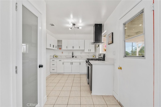 5619 Daisy Ave Unit 29, Palms, CA 92277 - kitchen with gas stove, wall chimney range hood, light countertops, light tile patterned floors, and open shelves