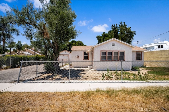 9804 Palmetto Ave, Fontana, CA 92335 - view of front of property featuring stucco siding, a fenced front yard, a detached garage, and driveway