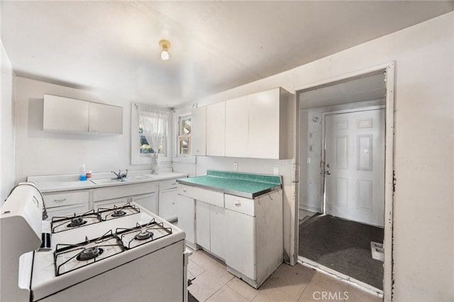 9804 Palmetto Ave, Fontana, CA 92335 - kitchen with gas range gas stove, white cabinetry, and light tile patterned floors