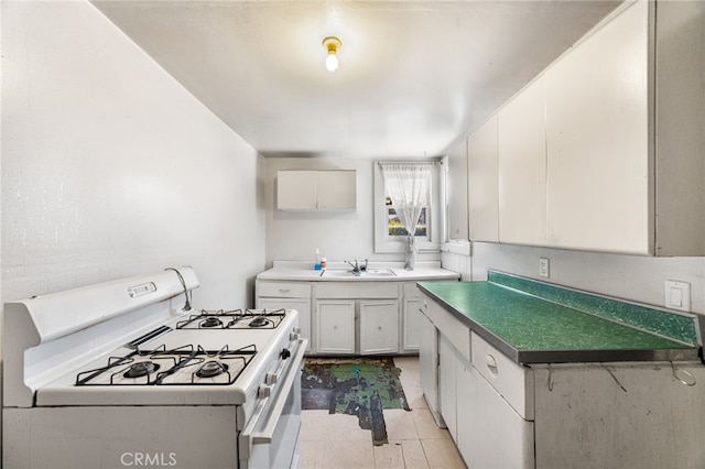 9804 Palmetto Ave, Fontana, CA 92335 - kitchen with white range with gas stovetop, white cabinetry, and light tile patterned flooring