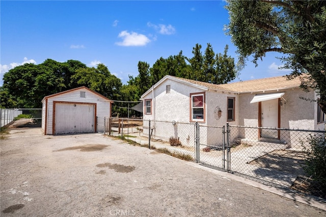 9804 Palmetto Ave, Fontana, CA 92335 - view of front of house featuring asphalt driveway, a gate, a garage, stucco siding, and an outdoor structure