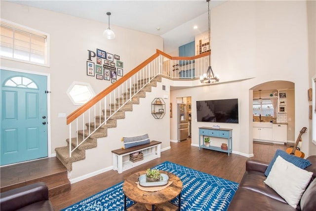 11025 Kenyon Way, Rancho Cucamonga, CA 91701 - living room featuring a high ceiling, stairs, wood finished floors, a chandelier, and arched walkways