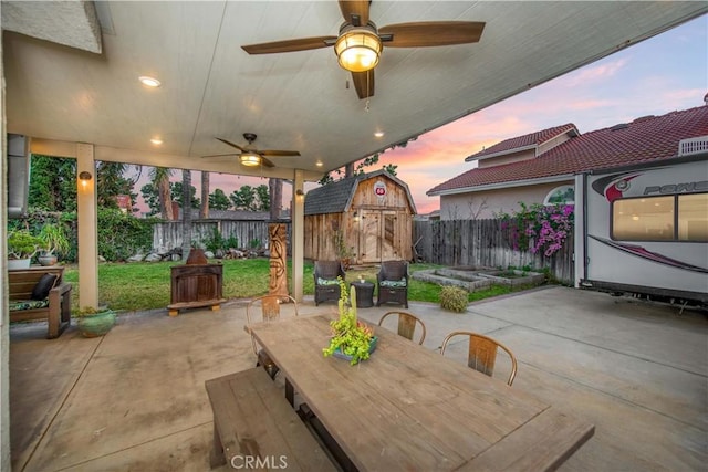 11025 Kenyon Way, Rancho Cucamonga, CA 91701 - patio terrace at dusk with a patio area, a fenced backyard, a shed, and ceiling fan
