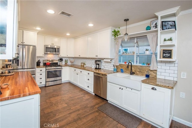 11025 Kenyon Way, Rancho Cucamonga, CA 91701 - kitchen featuring appliances with stainless steel finishes, butcher block countertops, tasteful backsplash, ornamental molding, and dark wood-style floors