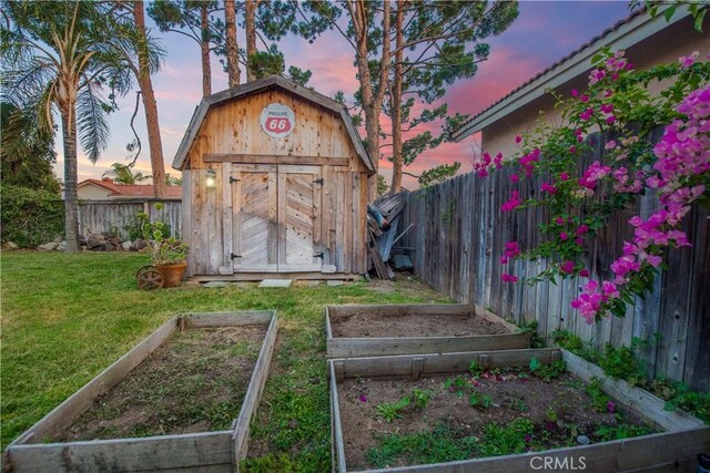 11025 Kenyon Way, Rancho Cucamonga, CA 91701 - outdoor structure at dusk featuring a vegetable garden, a storage shed, and a fenced backyard