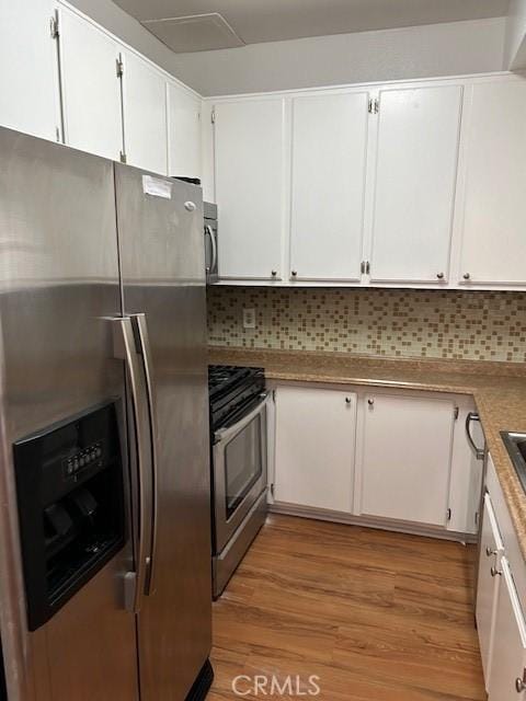 535 Magnolia Ave Unit 101, Long Beach, CA 90802 - kitchen with appliances with stainless steel finishes, white cabinets, light wood-type flooring, and tasteful backsplash