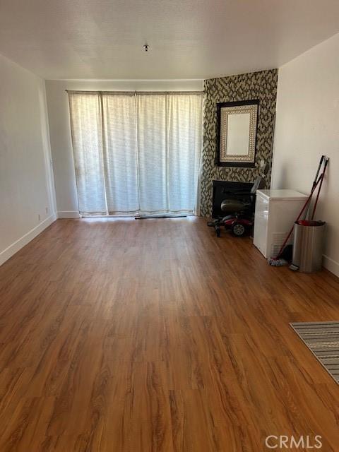 535 Magnolia Ave Unit 101, Long Beach, CA 90802 - unfurnished living room featuring plenty of natural light, wood finished floors, and a fireplace