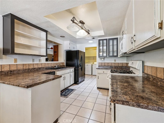 14719 Juniper St, Hesperia, CA 92345 - kitchen with independent washer and dryer, white appliances, dark countertops, a peninsula, and a textured ceiling