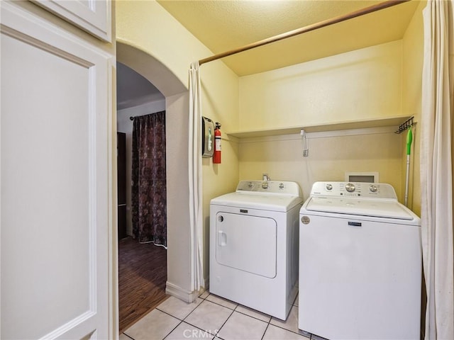 14719 Juniper St, Hesperia, CA 92345 - washroom with independent washer and dryer, arched walkways, and light tile patterned floors