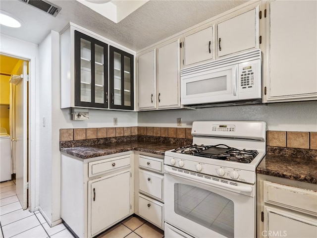 14719 Juniper St, Hesperia, CA 92345 - kitchen featuring white appliances, light tile patterned floors, glass insert cabinets, and dark countertops