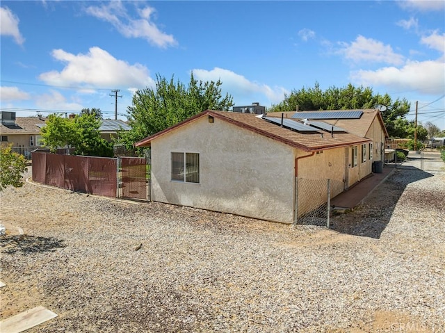 14719 Juniper St, Hesperia, CA 92345 - view of property exterior featuring a gate, stucco siding, and roof mounted solar panels
