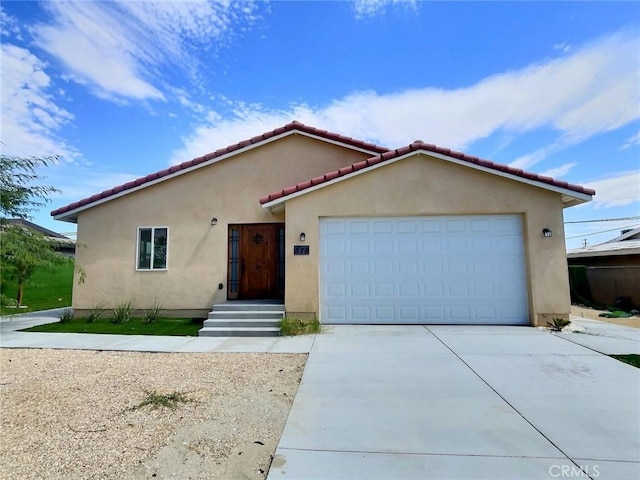 378 W Rosa Parks Rd, Palm Springs, CA 92262 - mediterranean / spanish house with driveway, stucco siding, a garage, and a tile roof