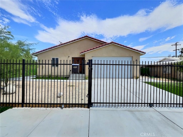 378 W Rosa Parks Rd, Palm Springs, CA 92262 - view of front facade featuring stucco siding, an attached garage, a fenced front yard, a tiled roof, and driveway