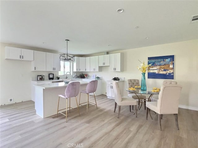 378 W Rosa Parks Rd, Palm Springs, CA 92262 - kitchen featuring a center island, light wood finished floors, white cabinets, light countertops, and recessed lighting